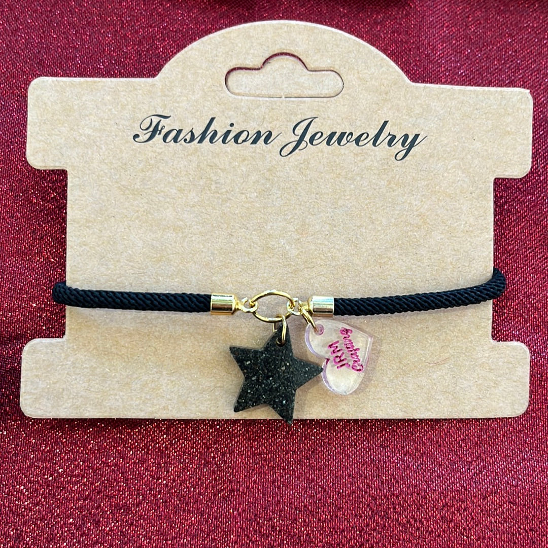 Pulsera estrella en arena de playa negra